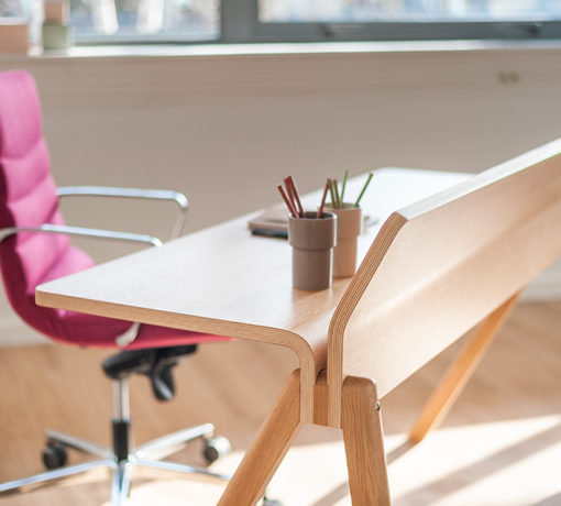 Table en bois élégante accompagnée d'un fauteuil dans l'espace de travail des Laboratoires Boiron, offrant un cadre chaleureux et fonctionnel pour des réunions ou des moments de détente.