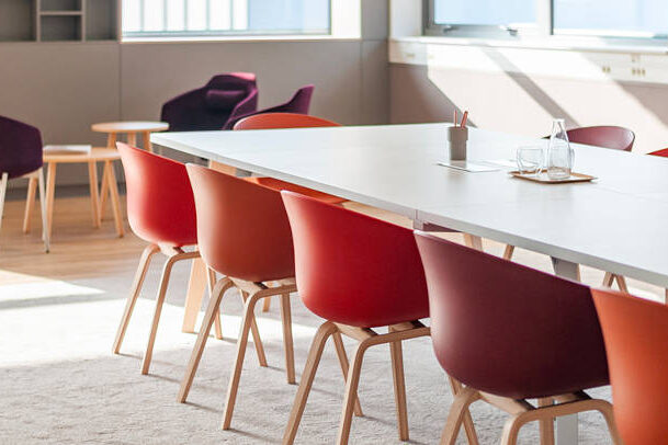 Salle de réunion aux Laboratoires Boiron, équipée de tables et de chaises confortables pour les réunions formelles, avec un espace additionnel comprenant des fauteuils pour des discussions informelles.