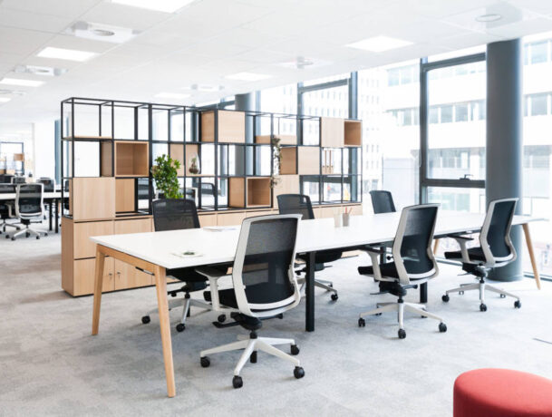 Bureau ouvert équipé de tables Woodesk et de sièges ergonomiques J1 avec un séparateur CORRAL, créant un espace de travail à la fois fonctionnel et ergonomique pour un confort optimal tout au long de la journée.