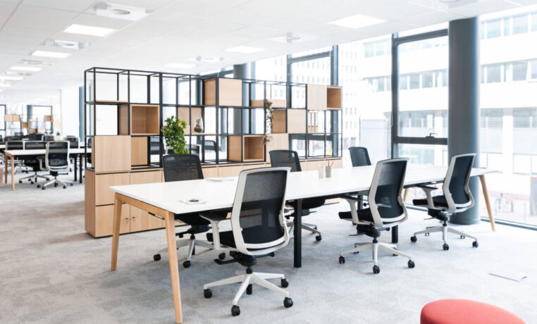 Bureau ouvert équipé de tables Woodesk et de sièges ergonomiques J1 avec un séparateur CORRAL, créant un espace de travail à la fois fonctionnel et ergonomique pour un confort optimal tout au long de la journée.