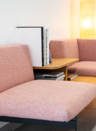 Deux fauteuils confortables disposés avec une table basse intégrée avec des magazines, créant un espace convivial et relaxant pour les pauses et les discussions informelles chez Techtera.