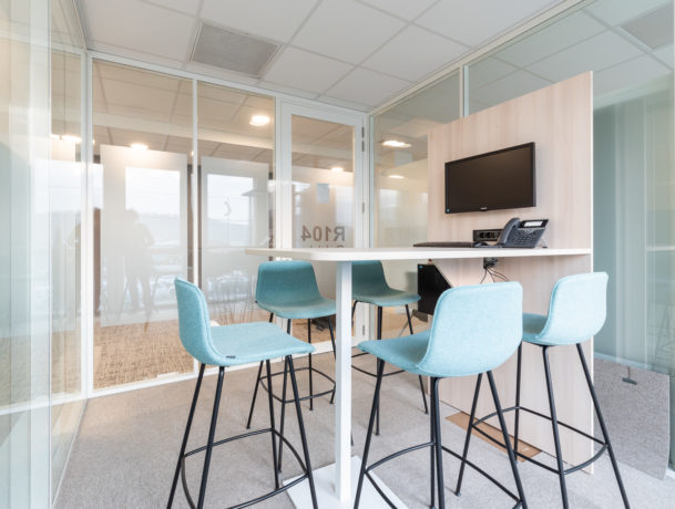 Salle de travail chez OPAC du Rhône, équipée de matériel audiovisuel grâce à la table haute TALK pour les présentations et les vidéoconférences, avec une disposition fonctionnelle pour faciliter les discussions en groupe.