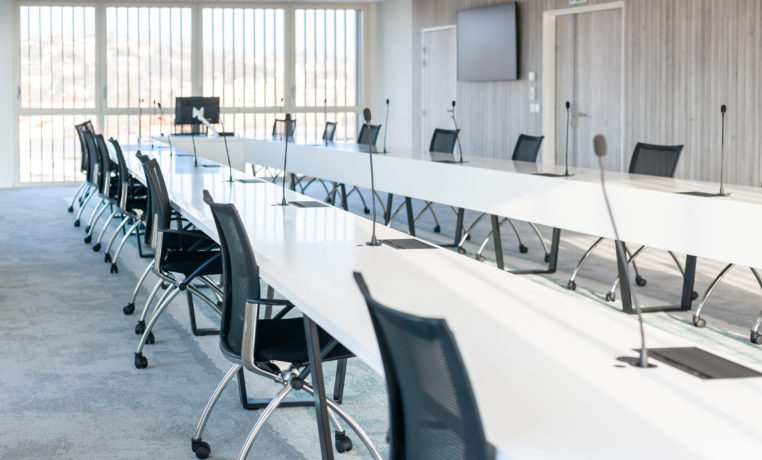 Grande salle de réunion moderne chez OPAC du Rhône, équipée d'une grande table de conférence entourée de chaises ergonomiques, idéale pour les réunions d'équipe et les présentations.