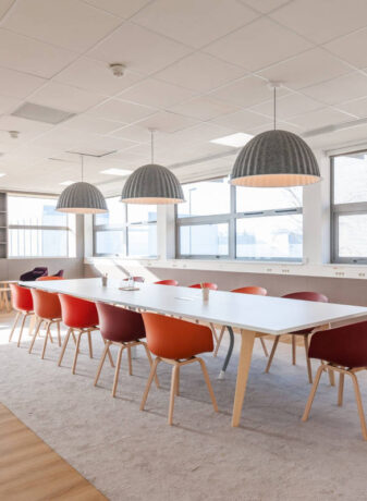 Salle de réunion chez Boiron au design scandinave, alliant simplicité et élégance avec des meubles en bois clair et des lignes épurées pour une ambiance professionnelle et accueillante.