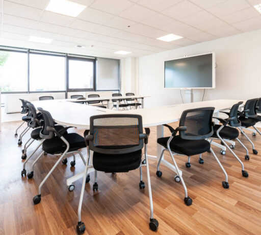 Table de réunion avec des tables modulables et des chaises Birdy, permettant une configuration flexible et un confort optimal pour les sessions de travail en groupe.