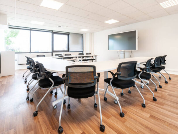 Table de réunion avec des tables modulables et des chaises Birdy, permettant une configuration flexible et un confort optimal pour les sessions de travail en groupe.