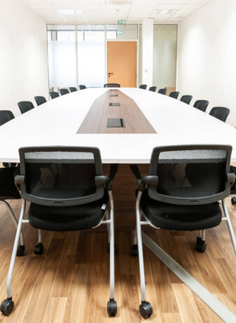 Salle de réunion spacieuse dotée d'une grande table et de chaises Birdy, offrant un cadre élégant et fonctionnel pour des discussions et des présentations en groupe.