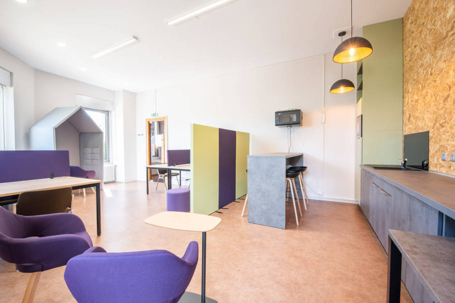 Vue d'ensemble de l'espace de coworking de la Mairie du Chambon-sur-Lignon, montrant un aménagement moderne avec des bureaux partagés, des zones de travail collaboratif, et des espaces de détente.