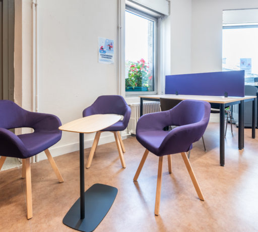 Espace détente dans l'espace de coworking, aménagé avec des chaises rembourrées confortables et une table WiFi, permettant aux utilisateurs de se reposer ou de travailler de manière informelle.