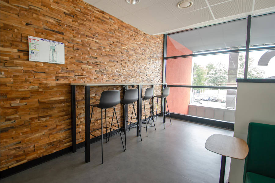 Deuxième espace de travail au CESI Arras équipé d'une table haute et d'un tabouret, fournissant une alternative moderne pour le travail en mode stand-up ou les discussions informelles.