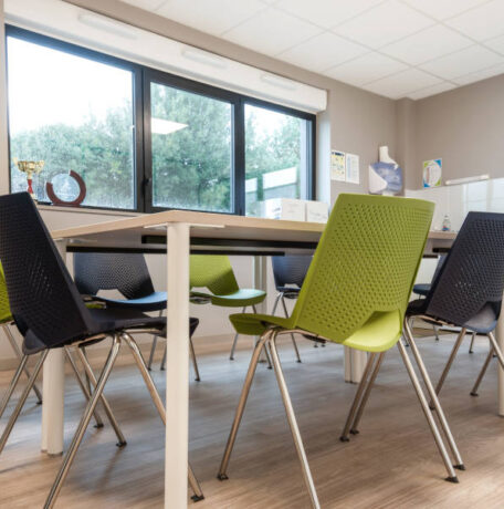 Salle de réunion moderne chez Ginger, équipée d'une grande table centrale et de chaises, conçue pour des réunions et des conférences de groupe.