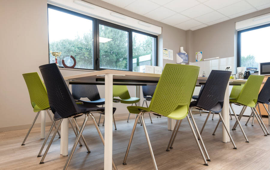 Salle de réunion moderne chez Ginger, équipée d'une grande table centrale et de chaises, conçue pour des réunions et des conférences de groupe.