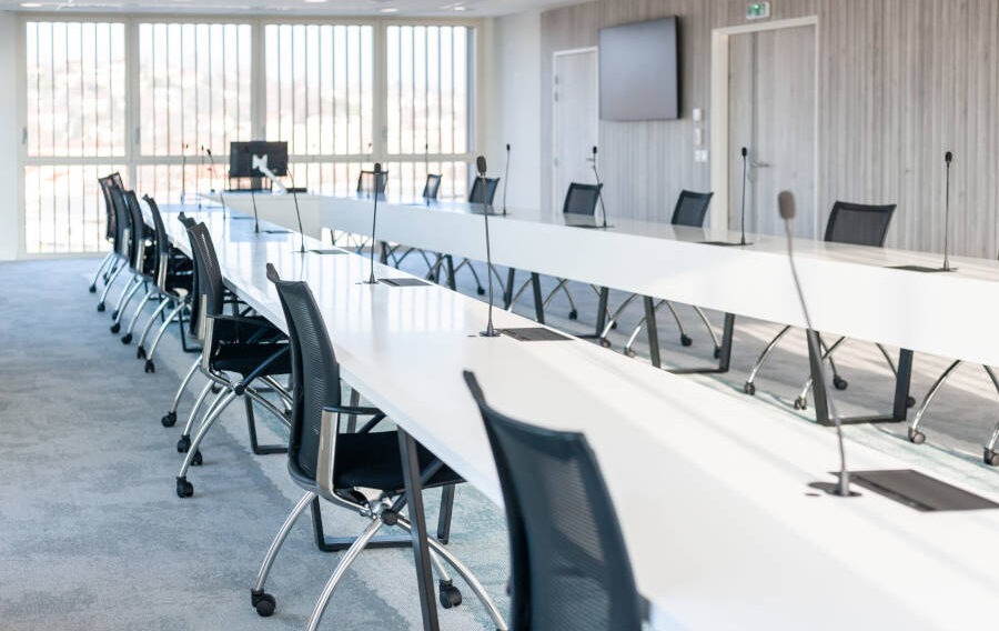 Grande salle de réunion moderne chez OPAC du Rhône, équipée d'une grande table de conférence entourée de chaises ergonomiques, idéale pour les réunions d'équipe et les présentations.