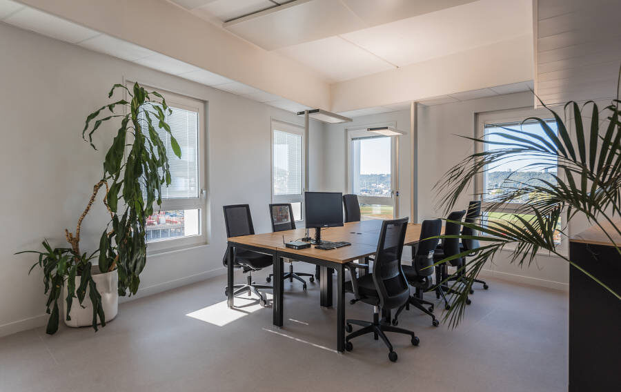 Salle de réunion chez Habitat 76, équipée de plusieurs tables U-DESK et de sièges ergonomiques, offrant un cadre professionnel pour les réunions et les présentations.