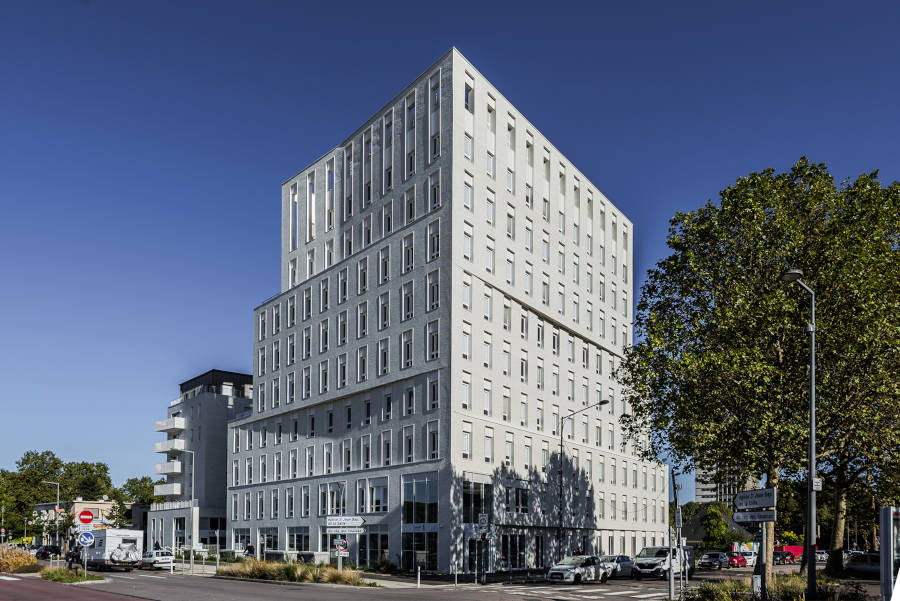 Vue extérieure du bâtiment Habitat 76, montrant la façade et architecturale de l'immeuble, avec des lignes épurées et de grandes fenêtres permettant une abondante lumière naturelle.