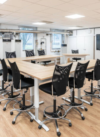 Zone de collaboration pour des formations chez Ariston, avec des tables réglables en hauteur et des sièges techniques ergonomiques, facilitant des configurations variées pour des réunions de groupe et des activités de collaboration.