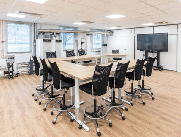 Zone de collaboration pour des formations chez Ariston, avec des tables réglables en hauteur et des sièges techniques ergonomiques, facilitant des configurations variées pour des réunions de groupe et des activités de collaboration.