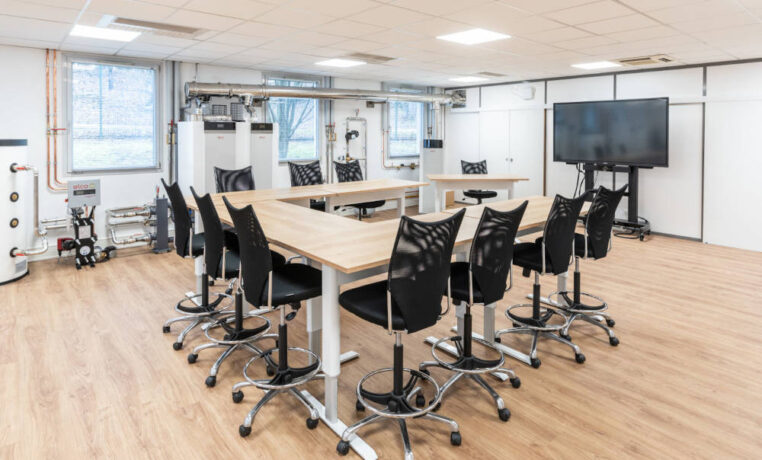 Zone de collaboration pour des formations chez Ariston, avec des tables réglables en hauteur et des sièges techniques ergonomiques, facilitant des configurations variées pour des réunions de groupe et des activités de collaboration.