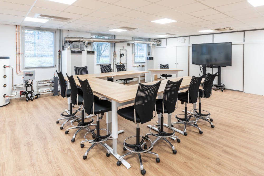 Zone de collaboration pour des formations chez Ariston, avec des tables réglables en hauteur et des sièges techniques ergonomiques, facilitant des configurations variées pour des réunions de groupe et des activités de collaboration.