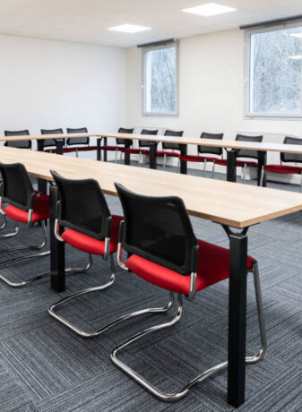 Salle de réunion chez Ariston, équipée d'une grande table de conférence entourée de chaises ergonomiques, créant un cadre idéal pour des réunions professionnelles et des présentations.