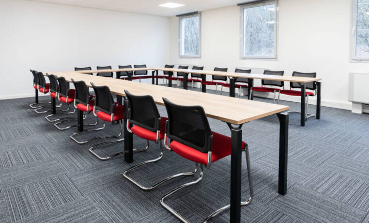 Salle de réunion chez Ariston, équipée d'une grande table de conférence entourée de chaises ergonomiques, créant un cadre idéal pour des réunions professionnelles et des présentations.