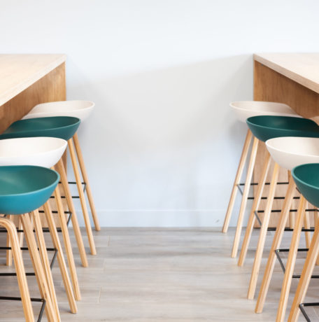 Réfectoire chez Carbogen Amcis, aménagé avec du mobilier moderne comprenant des tables haute SWARM et des tabourets élégantes aux couleurs de leur marque, offrant un espace convivial pour les pauses café et les repas informels.