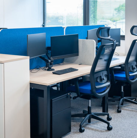 Open space avec des bureaux U-Desk séparés par des écrans acoustiques SILENS, complété par des caissons de rangement et un siège ergonomique, créant un environnement de travail moderne et fonctionnel.