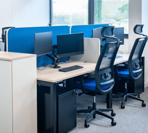 Open space avec des bureaux U-Desk séparés par des écrans acoustiques SILENS, complété par des caissons de rangement et un siège ergonomique, créant un environnement de travail moderne et fonctionnel.