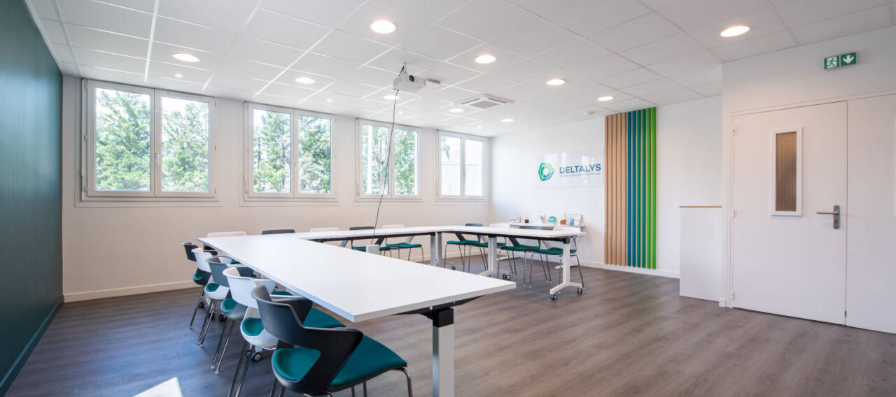 Salle de réunion chez Deltalys, aménagée avec des grandes tables à roulette et des chaises JOKY 4 pieds confortables, idéale pour les réunions d'équipe et les discussions stratégiques.