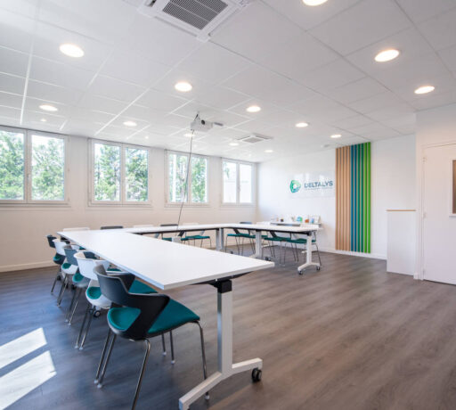 Salle de réunion chez Deltalys, aménagée avec des grandes tables à roulette et des chaises JOKY 4 pieds confortables, idéale pour les réunions d'équipe et les discussions stratégiques.