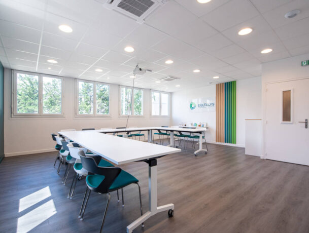 Salle de réunion chez Deltalys, aménagée avec des grandes tables à roulette et des chaises JOKY 4 pieds confortables, idéale pour les réunions d'équipe et les discussions stratégiques.