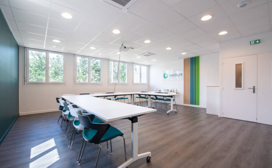 Salle de réunion chez Deltalys, aménagée avec des grandes tables à roulette et des chaises JOKY 4 pieds confortables, idéale pour les réunions d'équipe et les discussions stratégiques.