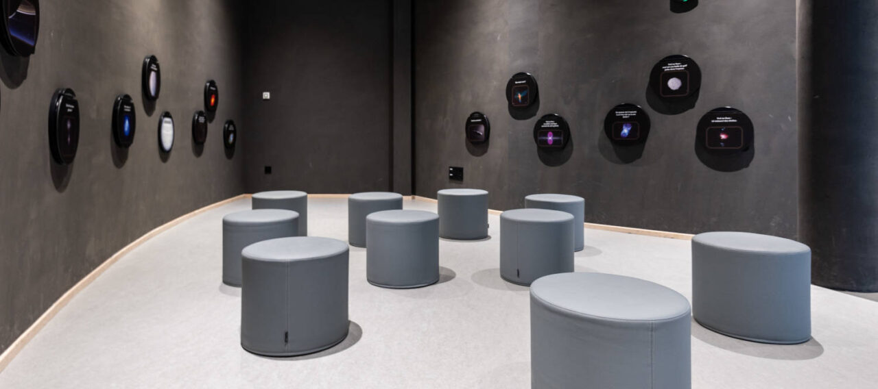 Espace d'attente chez Cosmocité, équipé de poufs Boom gris et confortables, créant un lieu informel et accueillant pour les visiteurs en attente.