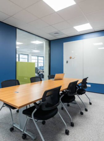 Salle de réunion Auvalie fonctionnelle avec des chaises Pogo et un tableau, offrant un cadre pratique pour des réunions interactives et des présentations visuelles.