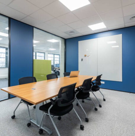 Salle de réunion Auvalie fonctionnelle avec des chaises Pogo et un tableau, offrant un cadre pratique pour des réunions interactives et des présentations visuelles.