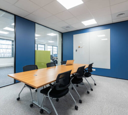 Salle de réunion Auvalie fonctionnelle avec des chaises Pogo et un tableau, offrant un cadre pratique pour des réunions interactives et des présentations visuelles.