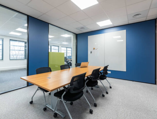 Salle de réunion Auvalie fonctionnelle avec des chaises Pogo et un tableau, offrant un cadre pratique pour des réunions interactives et des présentations visuelles.