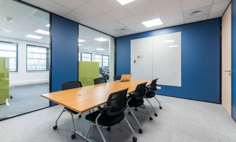 Salle de réunion Auvalie fonctionnelle avec des chaises Pogo et un tableau, offrant un cadre pratique pour des réunions interactives et des présentations visuelles.