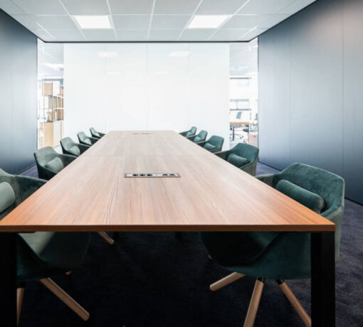 Boîtier prise FLAT installé dans un bureau en salle de réunion, illustrant son intégration fluide dans un espace de travail moderne avec un accès facile aux prises.