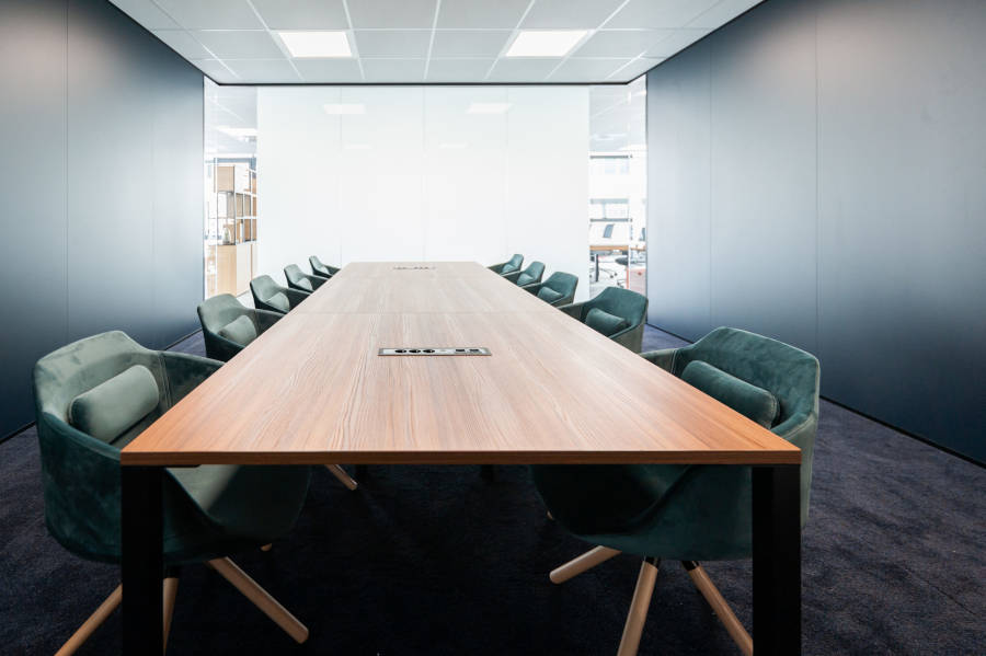 Boîtier prise FLAT installé dans un bureau en salle de réunion, illustrant son intégration fluide dans un espace de travail moderne avec un accès facile aux prises.