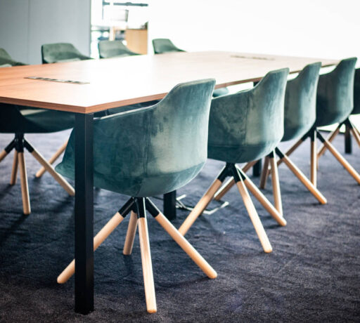 Salle de réunion élégante équipée d'une table Quattro et de fauteuils en velours, offrant un cadre raffiné et confortable pour des réunions importantes et des présentations.